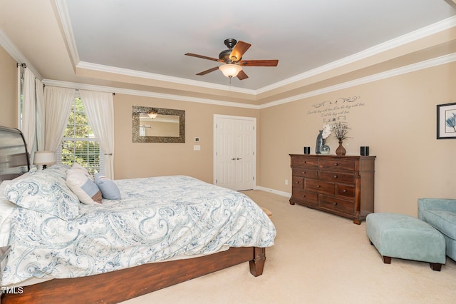 bedroom featuring crown molding, light colored carpet, a raised ceiling, ceiling fan, and baseboards