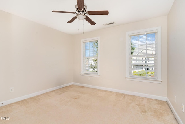 empty room with carpet floors, baseboards, and a ceiling fan