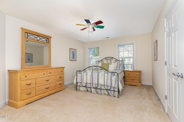 bedroom featuring light carpet, baseboards, and ceiling fan