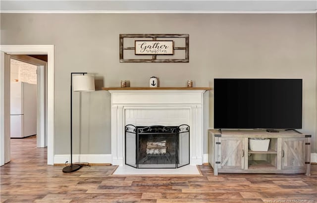 201 W 16th St, Lumberton, NC 28358 - living area with wood finished floors, crown molding, baseboards, and a fireplace with flush hearth