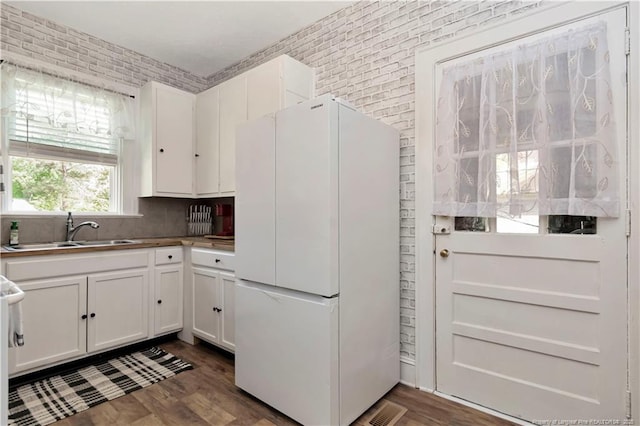 201 W 16th St, Lumberton, NC 28358 - kitchen with freestanding refrigerator, a sink, white cabinets, dark wood-style floors, and backsplash