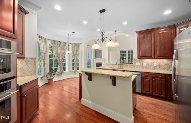 39 Forked Pine Ct, Chapel Hill, NC 27517 - kitchen with stainless steel appliances, a breakfast bar, recessed lighting, tasteful backsplash, and light stone countertops