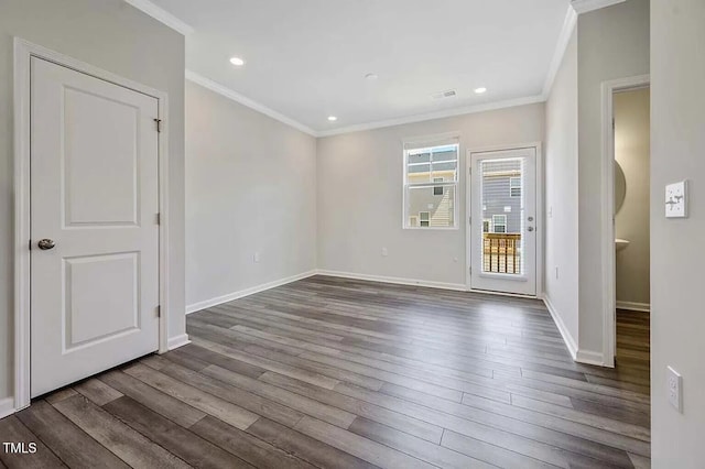 empty room featuring crown molding, dark wood-style flooring, baseboards, and recessed lighting