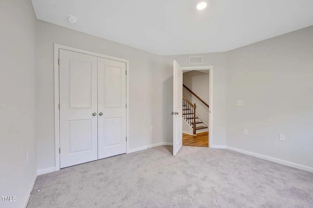 unfurnished bedroom with carpet flooring, a closet, and baseboards