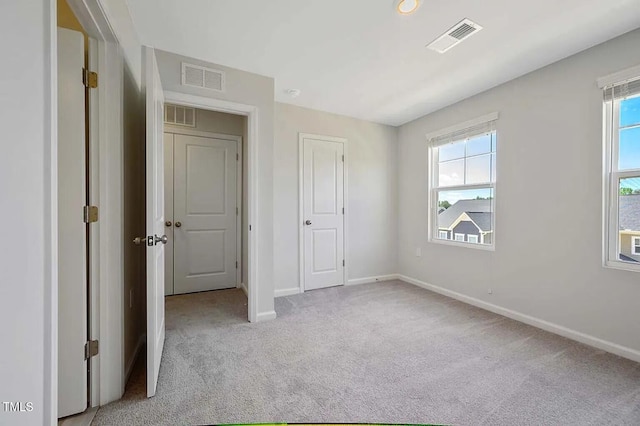 unfurnished bedroom with light carpet and baseboards