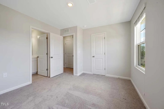 unfurnished bedroom featuring light colored carpet, baseboards, ensuite bathroom, and recessed lighting