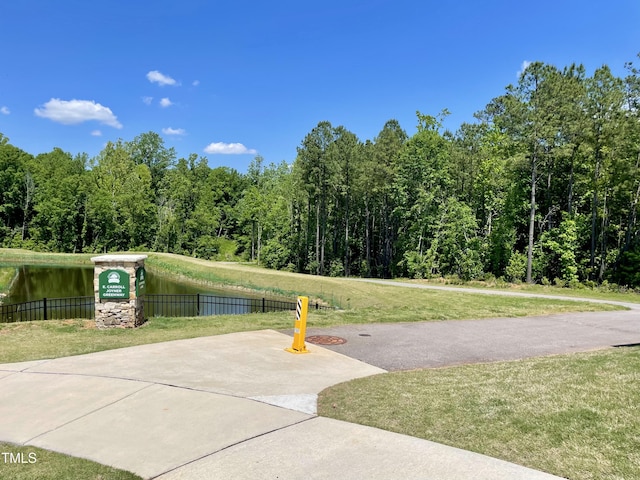 surrounding community featuring a water view and a forest view