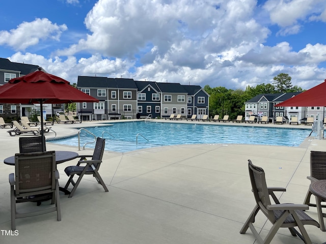 community pool with fence and a patio area