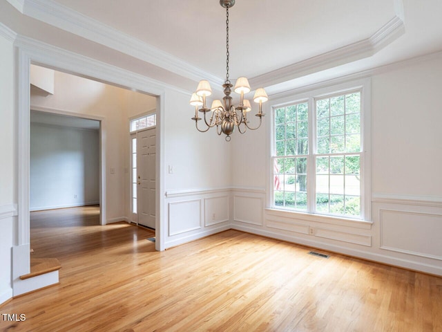 203 Chilcott Ln, Apex, NC 27502 - spare room with light wood-style floors, a chandelier, ornamental molding, a wainscoted wall, and a decorative wall