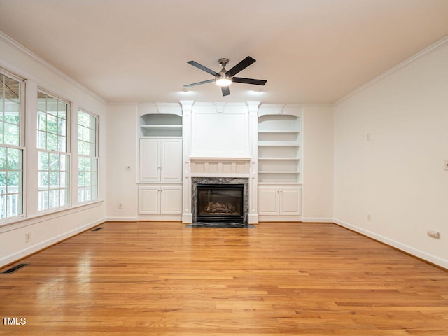 203 Chilcott Ln, Apex, NC 27502 - unfurnished living room featuring a ceiling fan, light wood-style flooring, baseboards, ornamental molding, and a high end fireplace
