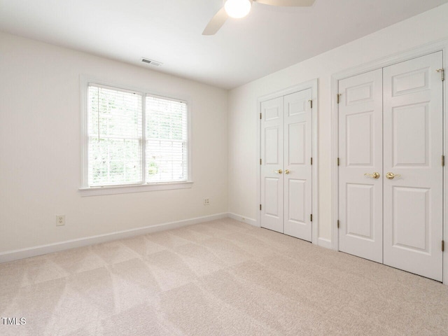 203 Chilcott Ln, Apex, NC 27502 - unfurnished bedroom featuring multiple closets, light carpet, baseboards, and ceiling fan