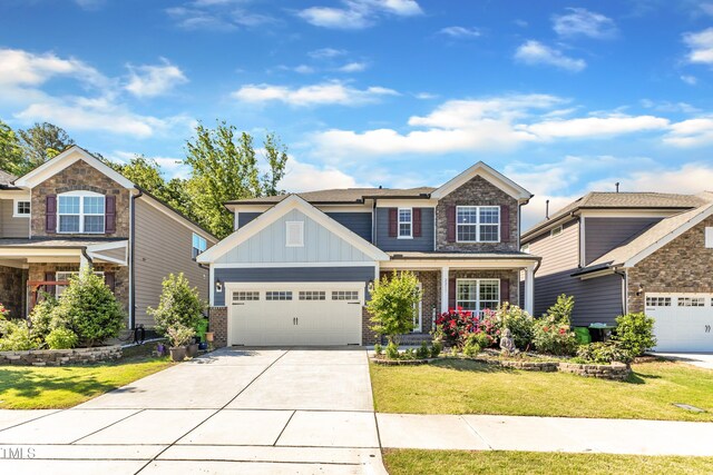 craftsman inspired home with board and batten siding, driveway, brick siding, an attached garage, and a front lawn