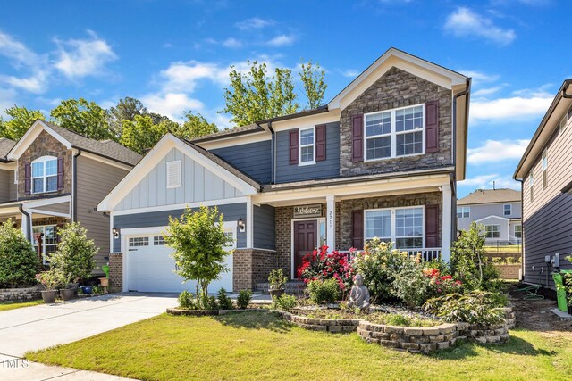 craftsman inspired home featuring board and batten siding, driveway, a front yard, a garage, and a porch