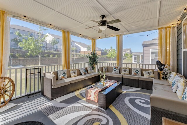 sunroom with outdoor lounge area, ceiling fan, and a residential view
