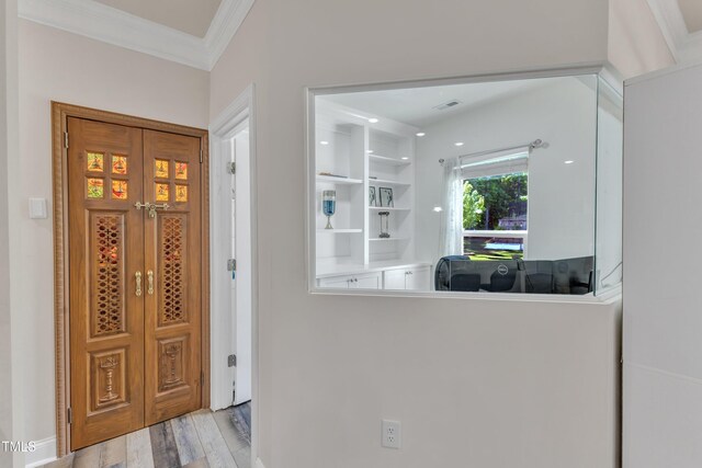 entrance foyer with ornamental molding and wood finished floors