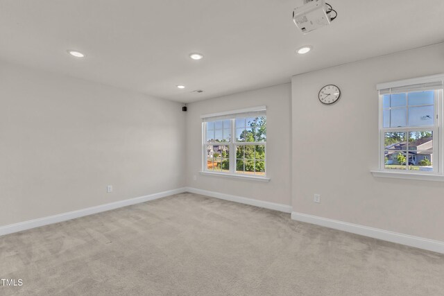 unfurnished room with light carpet, recessed lighting, and baseboards