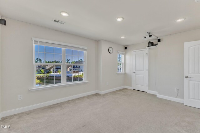 spare room featuring light carpet, baseboards, and recessed lighting