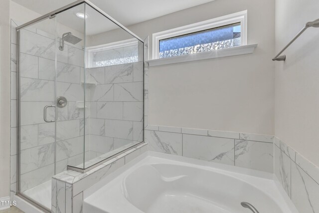 full bathroom with a stall shower and a bath