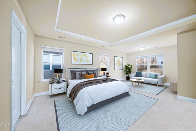 bedroom with a tray ceiling, light colored carpet, baseboards, and crown molding