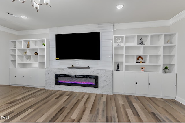 unfurnished living room with a glass covered fireplace, wood finished floors, ornamental molding, a chandelier, and recessed lighting