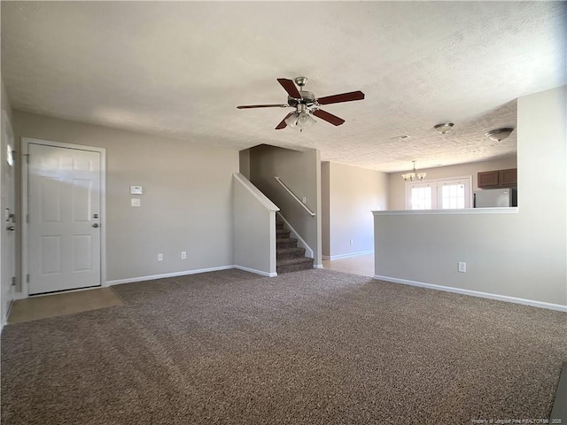 unfurnished living room featuring stairway, baseboards, a ceiling fan, a chandelier, and carpet flooring