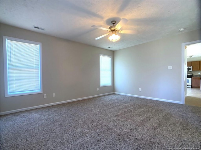 unfurnished room featuring ceiling fan, light colored carpet, and baseboards