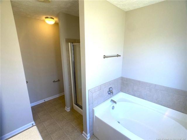 full bath with a shower stall, a bath, a textured ceiling, tile patterned flooring, and baseboards