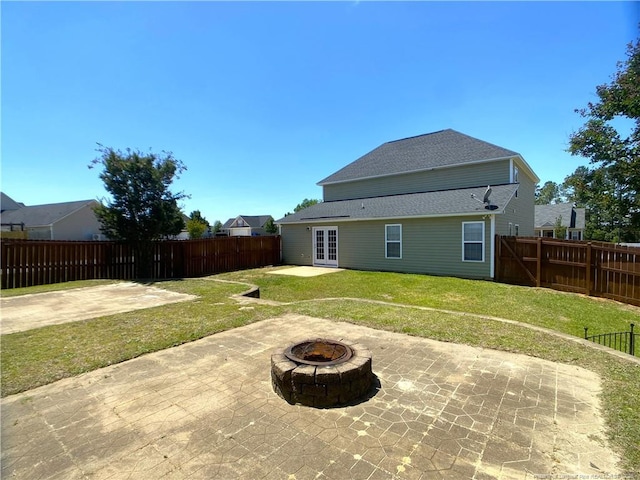 rear view of house with french doors, a patio area, an outdoor fire pit, and roof with shingles