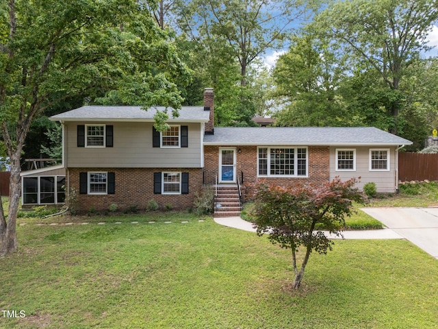 tri-level home with a chimney and brick siding