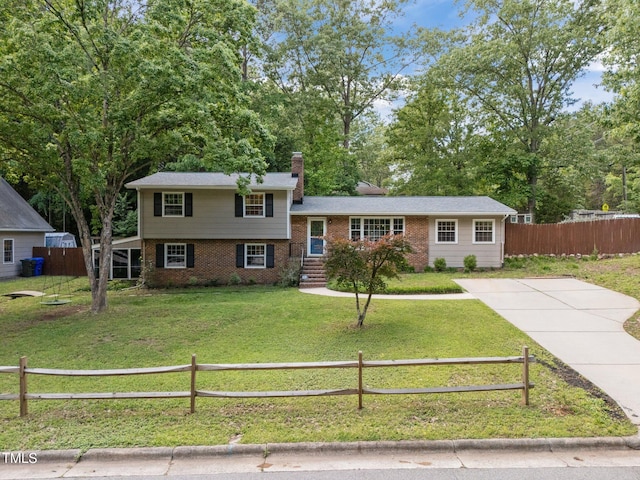 split level home with brick siding, a chimney, and driveway