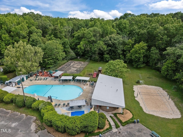 aerial view of property's location featuring a pool area and a forest
