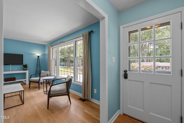 doorway to outside featuring light wood-style floors and baseboards