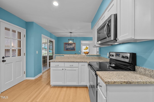 kitchen featuring appliances with stainless steel finishes, a peninsula, light wood-type flooring, and white cabinetry