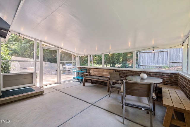 sunroom / solarium featuring outdoor dining area and plenty of natural light