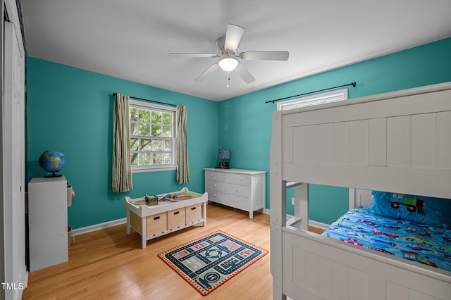 bedroom featuring light wood finished floors, ceiling fan, and baseboards