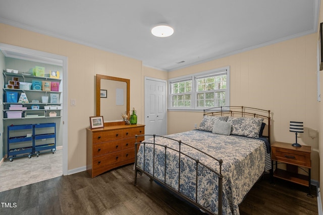 bedroom featuring wood finished floors, ornamental molding, and a closet