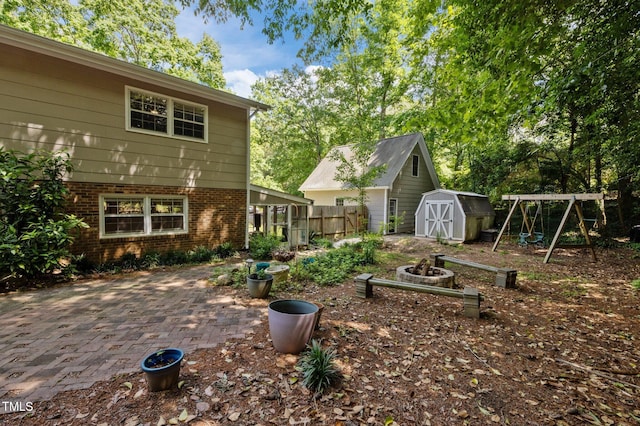 view of yard featuring a storage shed, a patio area, fence, and an outdoor structure