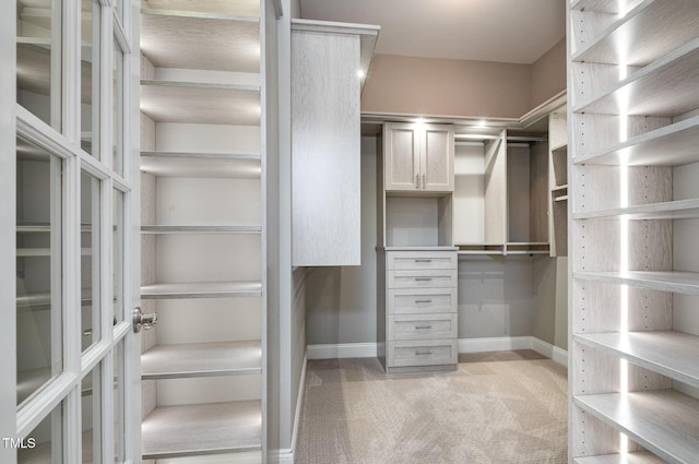 walk in closet featuring light carpet