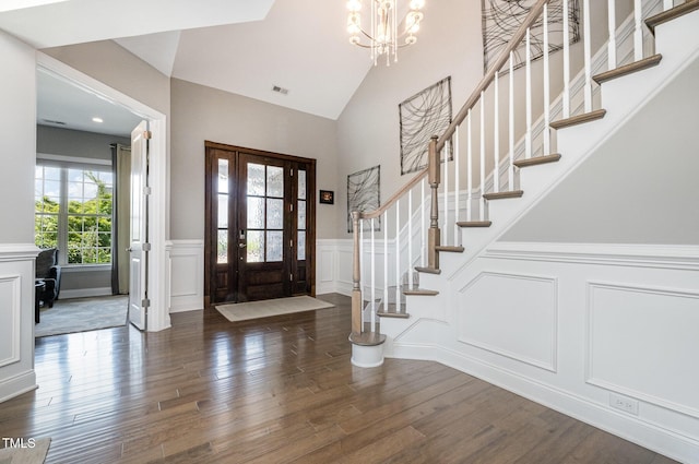 entrance foyer with a decorative wall, a chandelier, wood finished floors, stairway, and a wainscoted wall