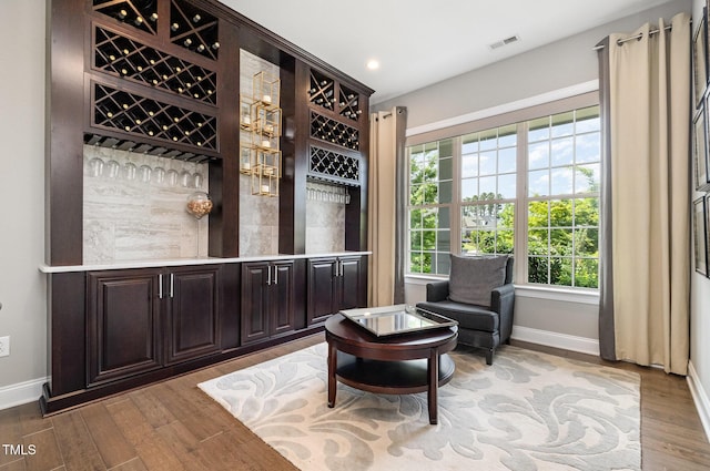 sitting room with baseboards, wood finished floors, and recessed lighting