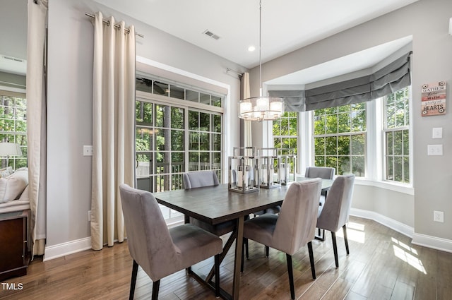 dining room with baseboards, healthy amount of natural light, and a chandelier