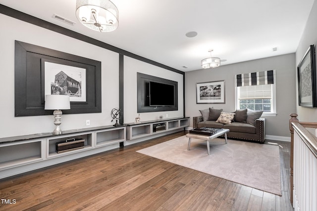 living room with wood finished floors, a chandelier, and baseboards