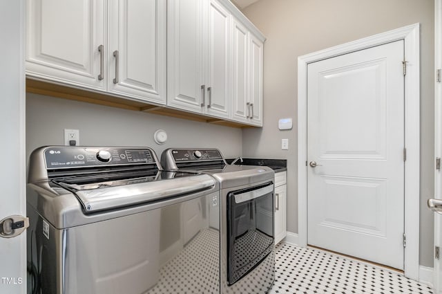 laundry room with independent washer and dryer, cabinet space, and baseboards
