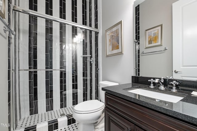 bathroom with toilet, a stall shower, and vanity