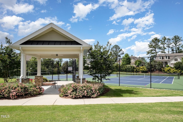 view of property's community featuring a tennis court and fence