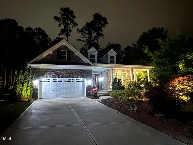 view of front of home featuring driveway and stone siding