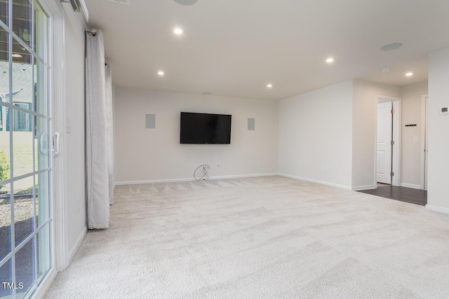 unfurnished living room with carpet, recessed lighting, and baseboards