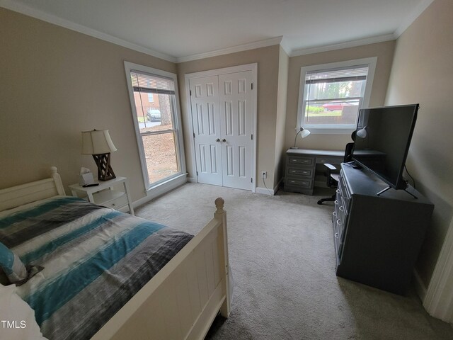 bedroom with light carpet, crown molding, baseboards, a closet, and a desk