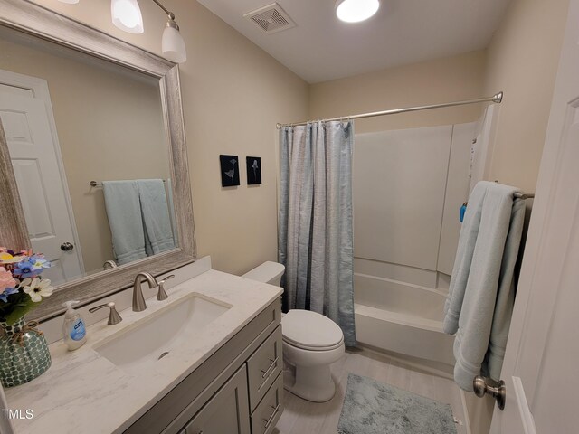 full bath with toilet, vanity, wood finished floors, and shower / tub combo