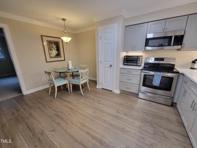 kitchen featuring appliances with stainless steel finishes, crown molding, light countertops, and gray cabinets